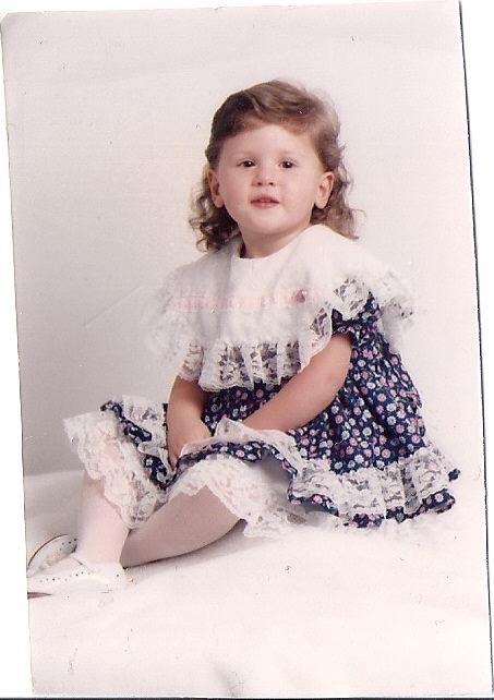 Jessi posing for a photo as a toddler